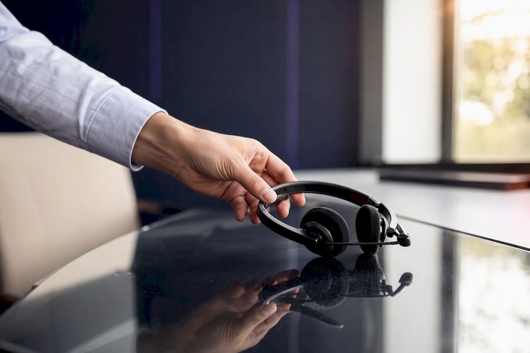 Hand placing headset on desk